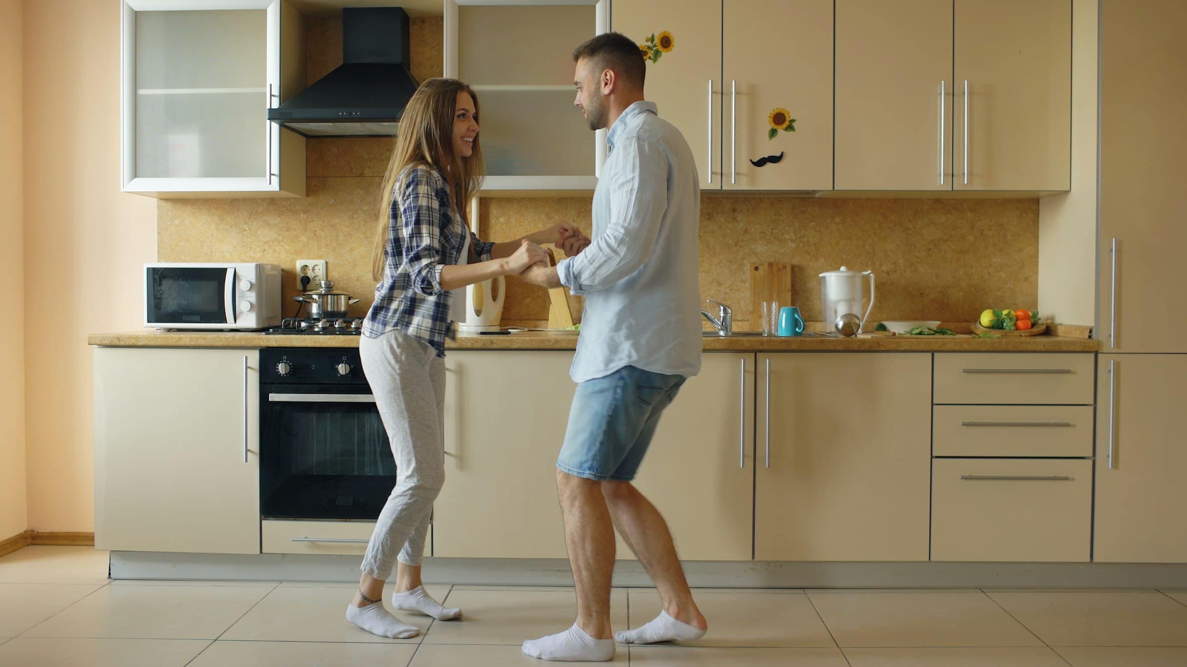 A couple at home in a sunlit kitchen — the relief of finally getting the escrow refund they were owed.